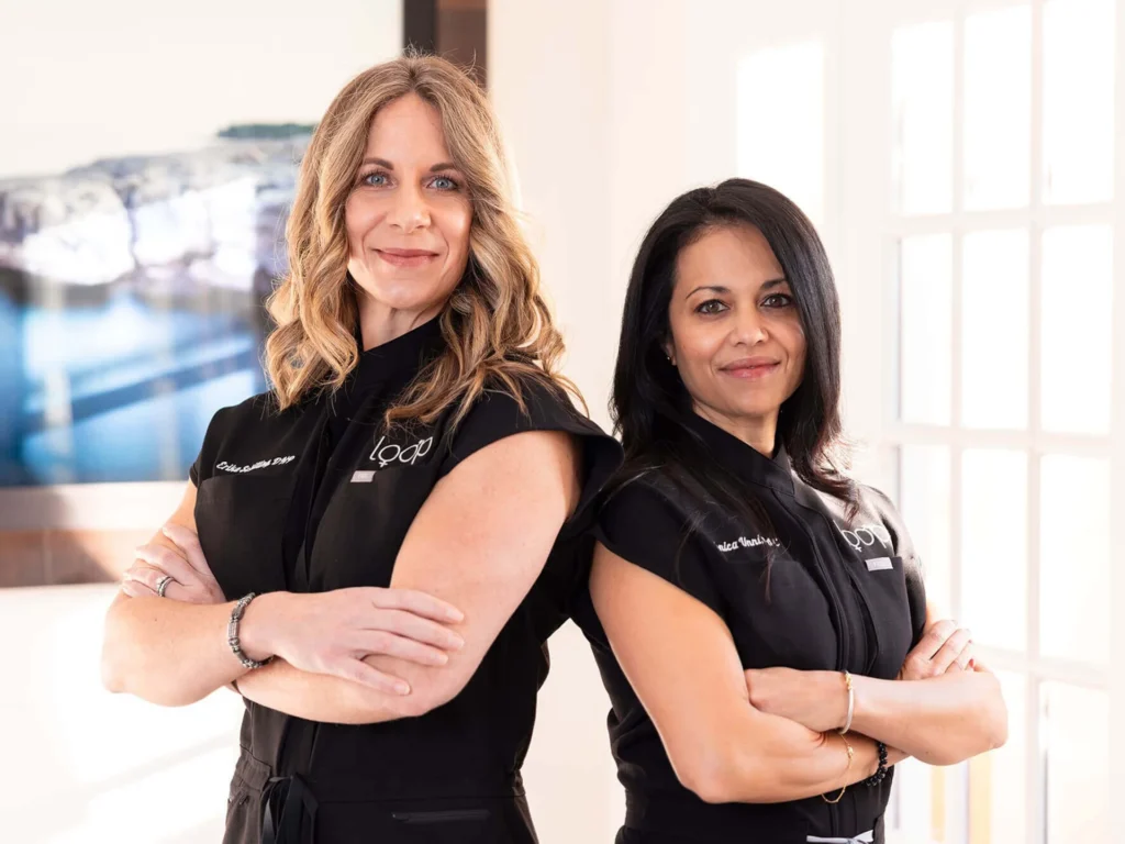 Two members of the Loop Wellness Clinic care team in black Loop uniforms